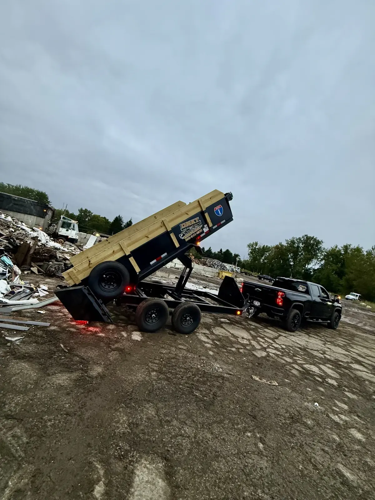 DMKT Disposal dump trailer unloading junk at a disposal facility